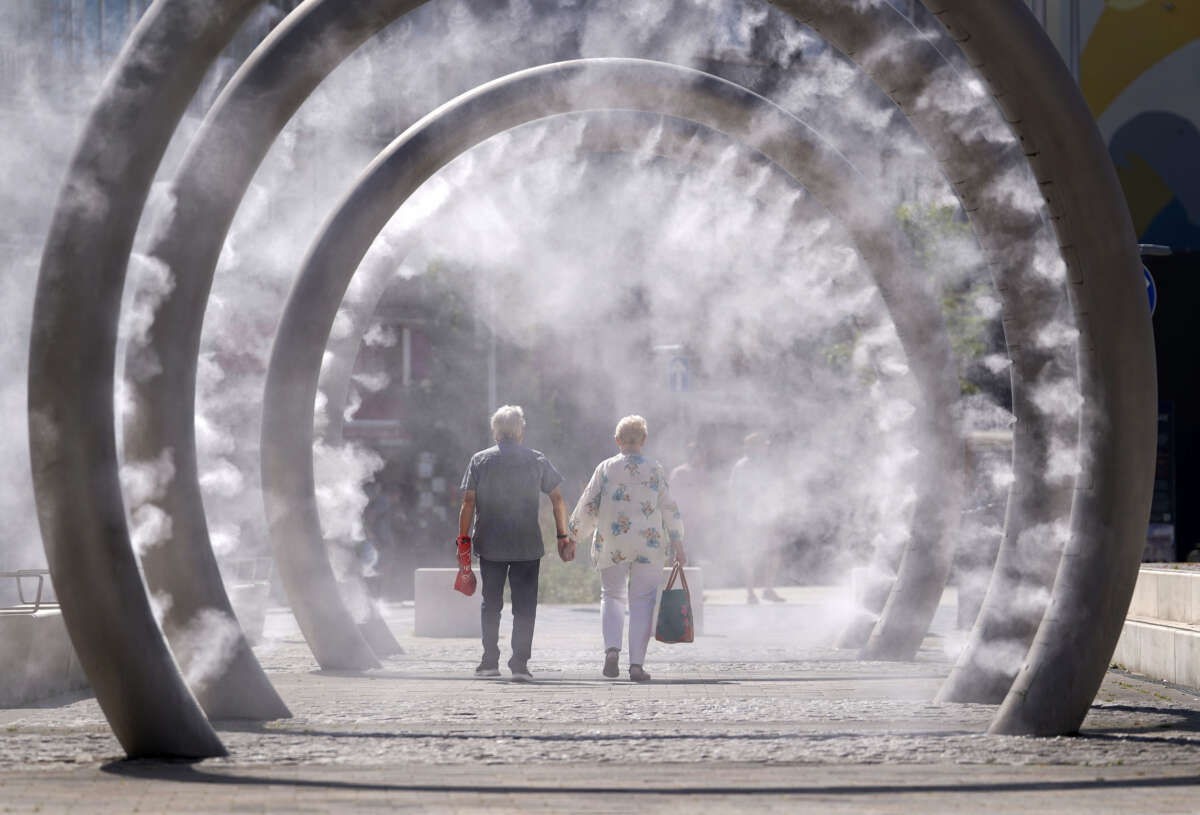 A couple cool off as they walk through a cooling water feature spraying a fine mist in Dover, Kent, as the third heatwave of the summer hits the UK and temperatures expected to remain high into the weekend, on July 11, 2025.
